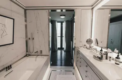 a bathroom with two sinks and a large mirror at Fasano Fifth Avenue I Private Members Club & Hotel in New York