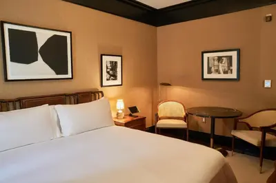 a bedroom with a bed and a table and chairs at Fasano Fifth Avenue I Private Members Club & Hotel in New York