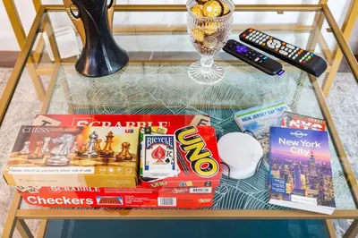 a table with books and games and a remote control at Luxury Suite by Prudential Ctr & 7min to EWR Airpt in Newark