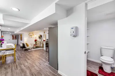 a bathroom with a toilet and a living room at Luxury Suite by Prudential Ctr & 7min to EWR Airpt in Newark