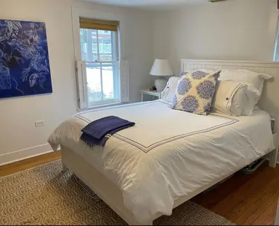a bedroom with a large white bed with pillows at Stylish Victorian Beach House on pond in Rowayton