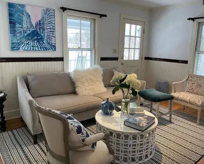 a living room with a couch and a table at Stylish Victorian Beach House on pond in Rowayton