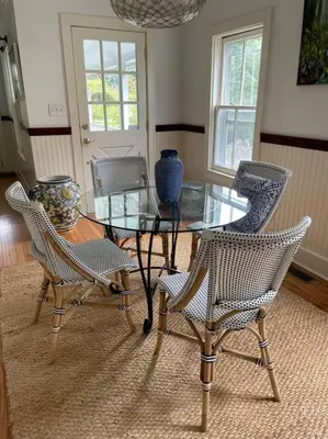 a dining room with a glass table and chairs at Stylish Victorian Beach House on pond in Rowayton