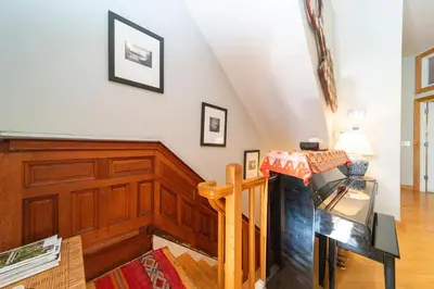 a living room with a staircase and wood paneling at 2 bedrooms with one private bathroom in lovely home in New York