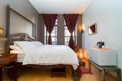 a bedroom with a bed and a desk and a window at 2 bedrooms with one private bathroom in lovely home in New York