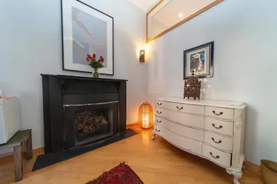 a living room with a fireplace and a white dresser at 2 bedrooms with one private bathroom in lovely home in New York