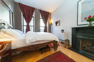 a bedroom with a bed and a fireplace at 2 bedrooms with one private bathroom in lovely home in New York