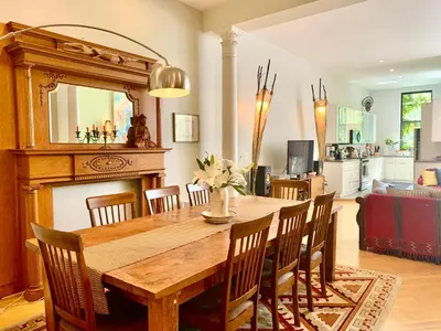 a dining room with a wooden table and chairs at 2 bedrooms with one private bathroom in lovely home in New York