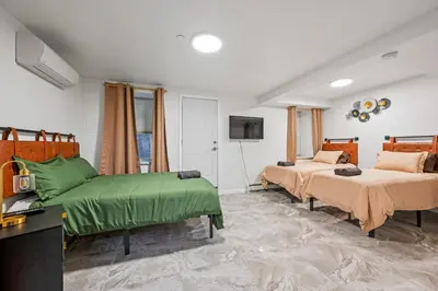 a bedroom with two beds with green sheets and a tv at Active Central Park East 3bedrooms 2 bathrooms 1700 SF in New York