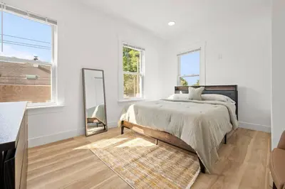 a white bedroom with a bed and a mirror at NYC Access 4BR Duplex Sleeps 10, Free Parking in Fair Lawn