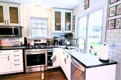 a kitchen with a sink and a stove top oven at The Jewel of The Cove - Historic Coastal Retreat in New Haven