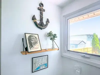 a room with a window with a anchor on the wall at The Jewel of The Cove - Historic Coastal Retreat in New Haven