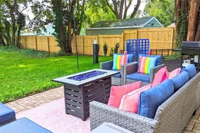 a patio with chairs and a table and a grill at The Jewel of The Cove - Historic Coastal Retreat in New Haven