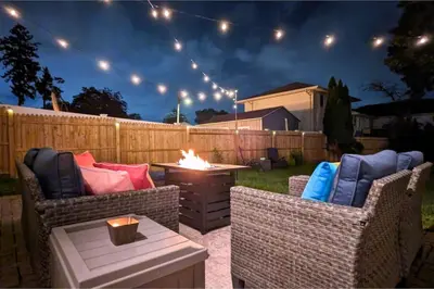 a backyard with two wicker chairs and a fire pit at The Jewel of The Cove - Historic Coastal Retreat in New Haven