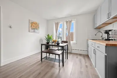 a white kitchen with a table and chairs in it at Downtown Hartford 2BR Family Pet Friendly in Hartford