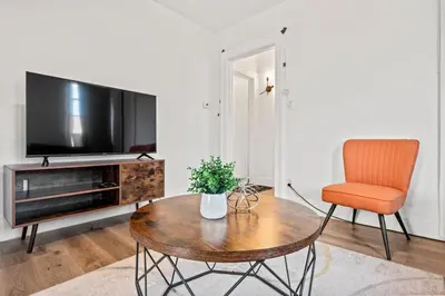 a living room with a table and a chair and a television at Downtown Hartford 2BR Family Pet Friendly in Hartford