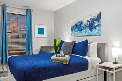 a bedroom with a blue and white bed and a window at Central Location Studio, Walk to Times Square in New York