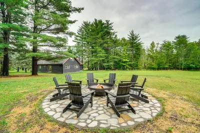 a fire pit with chairs and a table in a field at Stylish Catskills Retreat Year-Round Adventure! in Round Top