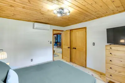 a room with a bed and a flat screen tv at Stylish Catskills Retreat Year-Round Adventure! in Round Top