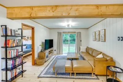 a living room with a couch and a book shelf at Stylish Catskills Retreat Year-Round Adventure! in Round Top