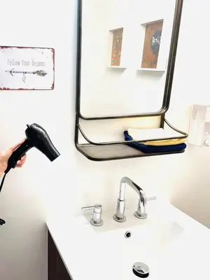 a bathroom sink with a blow dryer next to a mirror at Catskills, The Bohemian Dream in Shandaken
