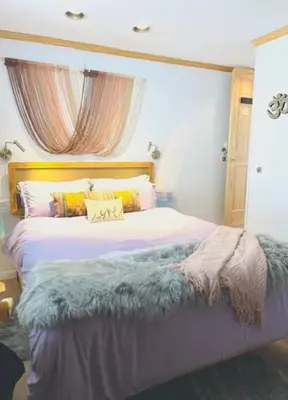 a bedroom with a large bed with a blue blanket at Catskill Cabin Bird of Paradise 7 in Shandaken