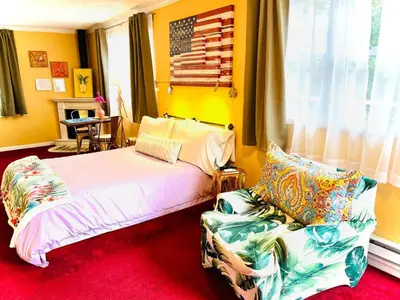 a bedroom with a bed and a chair and an american flag at Catskill Cabin The Flamingo Suite 5 in Shandaken
