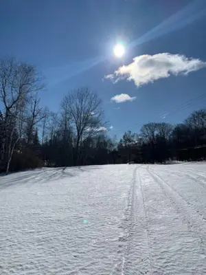a snow covered field with the sun in the sky at Catskill Cabin The Flamingo Suite 5 in Shandaken