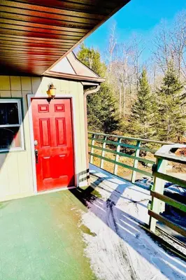 a red door on a house with a fence at Catskill Cabin The Flamingo Suite 5 in Shandaken