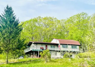 a large house in the middle of a field at Red Peacock Catskill Cabin sleeps four 6 in Shandaken