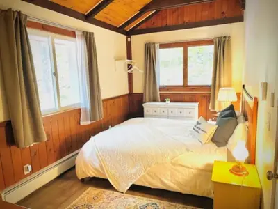 a bedroom with a large bed in a room with windows at Catskill Cabin Duplex Apartment in Shandaken