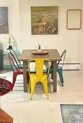 a wooden table with a yellow chair in a room at Catskill Cabin Duplex Apartment in Shandaken