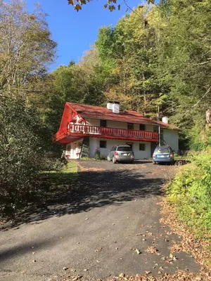 a house with two cars parked in front of it at Catskill Cabin Duplex Apartment in Shandaken