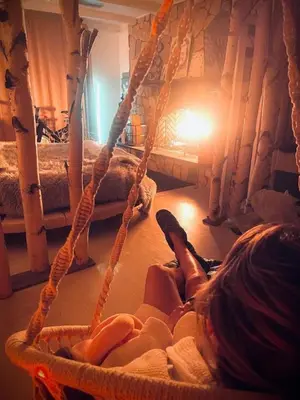 a woman laying on the floor in a hanging bed at Guest Favorite Garuda Apartment 8 in Shandaken