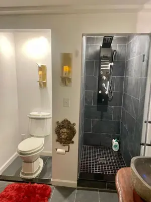 a bathroom with a shower with a toilet and a sink at Guest Favorite Garuda Apartment 8 in Shandaken