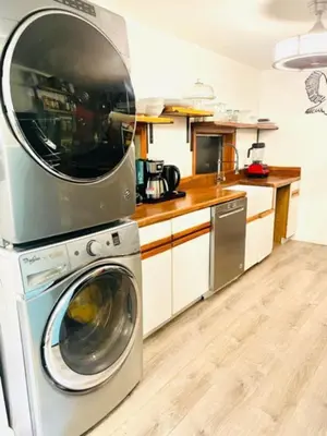 a kitchen with a washing machine with a microwave at Guest Favorite Garuda Apartment 8 in Shandaken