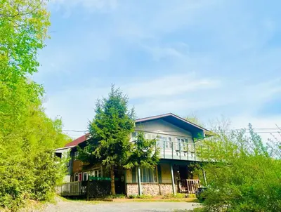 a house with a tree in front of it at Guest Favorite Garuda Apartment 8 in Shandaken