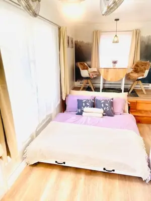 a bed in a room with a window at Catskill Cabin Little Owl Apt 1 in Shandaken
