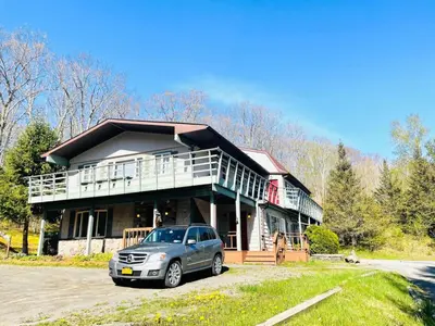 a house with a car parked in front of it at Catskill Cabin Zen Mantra Apt in Shandaken