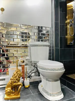 a bathroom with a toilet and a gold statue at Paloma, Large Attic Apartment in Shandaken