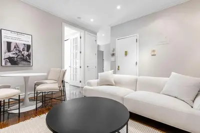 a living room with a white couch and a table at Gorgeous & Bright 3BDR & 1BTH in Midtown Manhattan in New York