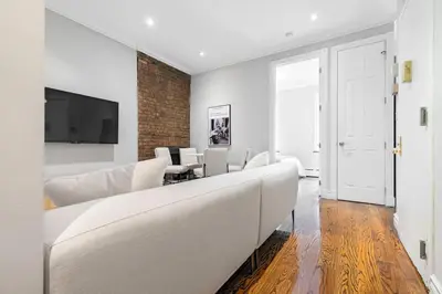 a living room with a white couch and a tv at Gorgeous & Bright 3BDR & 1BTH in Midtown Manhattan in New York