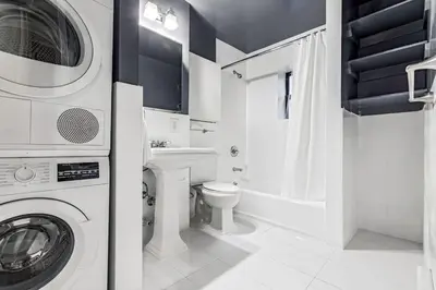a bathroom with a washing machine and a toilet at Gorgeous & Bright 3BDR & 1BTH in Midtown Manhattan in New York