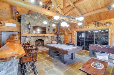 a pool table in a room with a stone fireplace at Elegant Hudson Valley Retreat with Hot Tub and Pond in Austerlitz