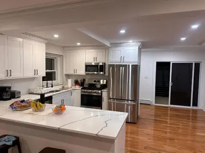 a kitchen with white cabinets and a stainless steel refrigerator at 4 bed Luxury house in Schenectady
