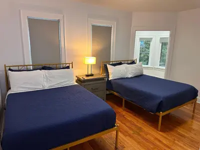 a bedroom with two beds and a lamp on a table at 4 bed Luxury house in Schenectady