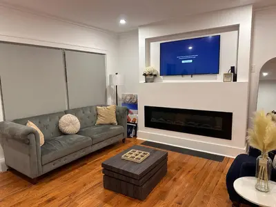 a living room with a couch and a flat screen tv at 4 bed Luxury house in Schenectady