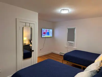 a bedroom with two beds and a tv on the wall at 4 bed Luxury house in Schenectady