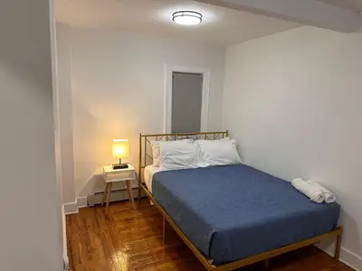 a small bedroom with a bed and a lamp at 4 bed Luxury house in Schenectady