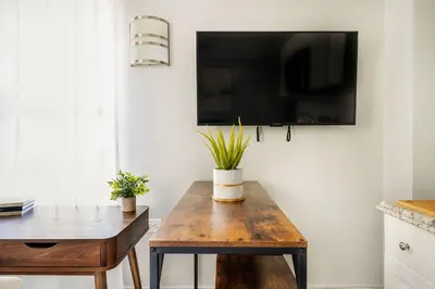 a living room with a wooden table and a tv at 73-1504 Newly Reno Studio UWS Doorman Gym Laundry in New York